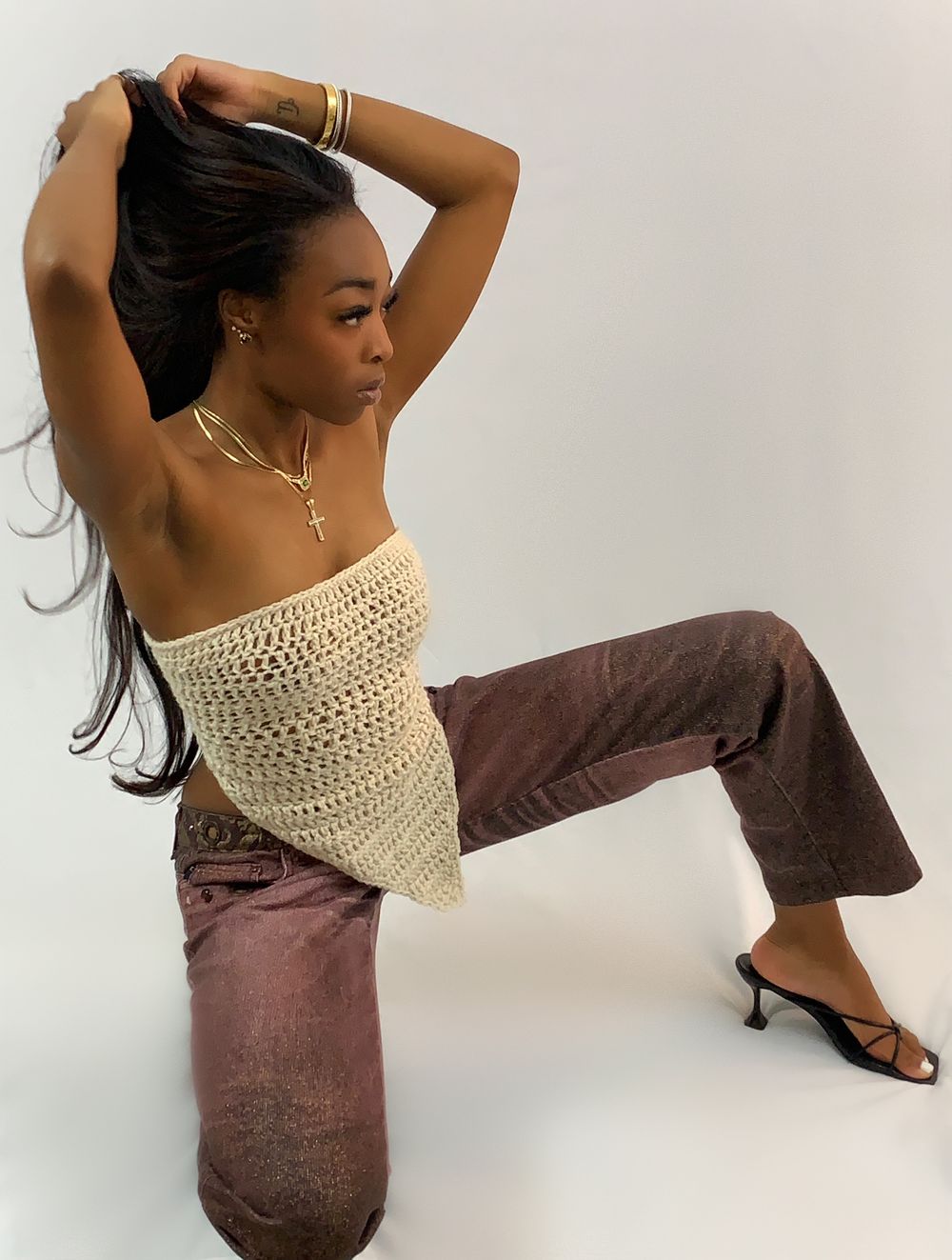 Misha kneeling in the cream crochet tube top, arms raised